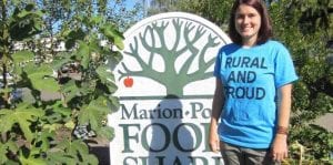 Student standing in front of a Food Bank sign