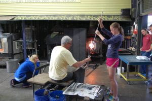 Bronwyn Gairing (left), Stephen Powell (center), and Cheyenne Evans (right), work on a project in the hot glass studio