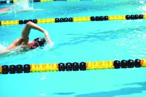 Senior Sam Walker swims freestyle during a race this season