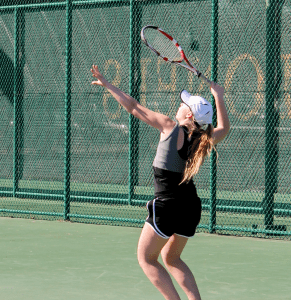 First-year Women’s Tennis player Kate Tomey serves a shot over the net during action from a match earlier in the 2014 campaign