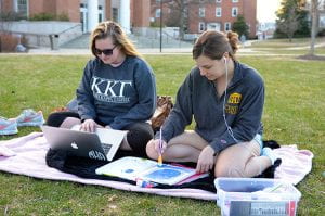 Pictured: Sophomores Meredith Harbison and Kelsie Essel Photo taken by Katherine Mackin Meredith Harbison and  Kelsie Essel take advantage of the warm spring weather to do homework on the lawn.