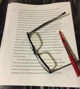 An essay, glasses and a red pen