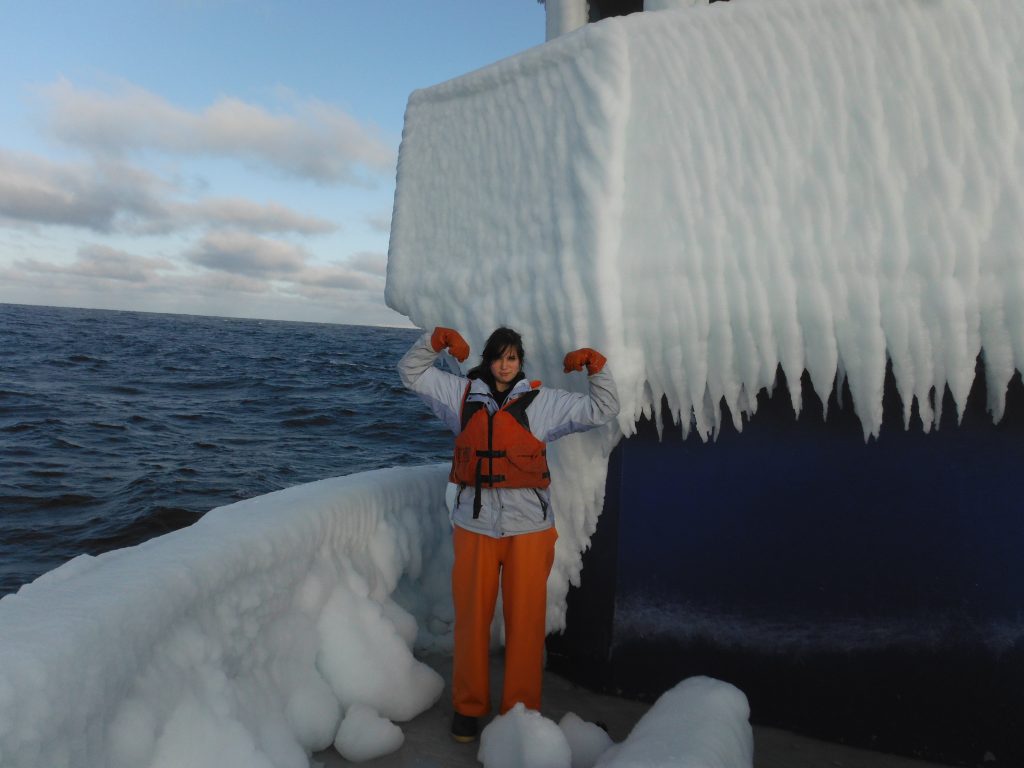 Lindsey, on the bow  of a fishing boat covered in ice in Alaska