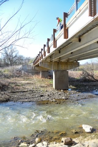 Dr. Bradley Austin collects a water sample to monitor water quality in Northwest Arkansas.