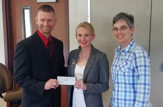 Jason Wagganer, president of the Central States chapter, presents an award check to Megan Rosa-Caldwell. Michelle Gray, right, was elected the regional chapter representative.