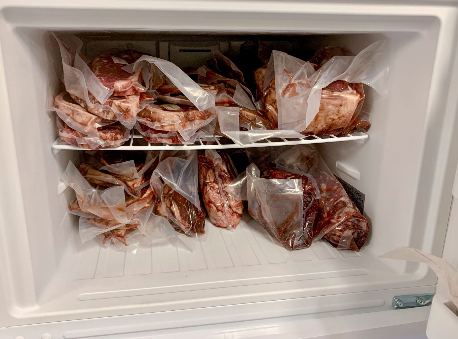 Beef packages organized in a chest freezer showing proper bulk beef storage