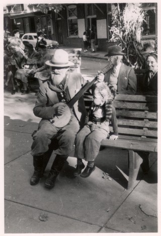 Booth Campbell performing alongside a little boy in a coonskin cap in Basin Park in Eureka Springs, Arkansas, during the Ozark Folk Festival, ca. 1950. From the "Ozark Encyclopedia" in the Otto Ernest Rayburn Papers (MS R19). 