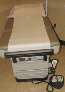 An exam table with a remote control nearby