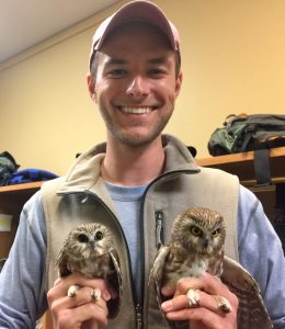 Mitchell Pruitt holds two northern saw-whet owls that were captured at the Ozark Natural Science Center.