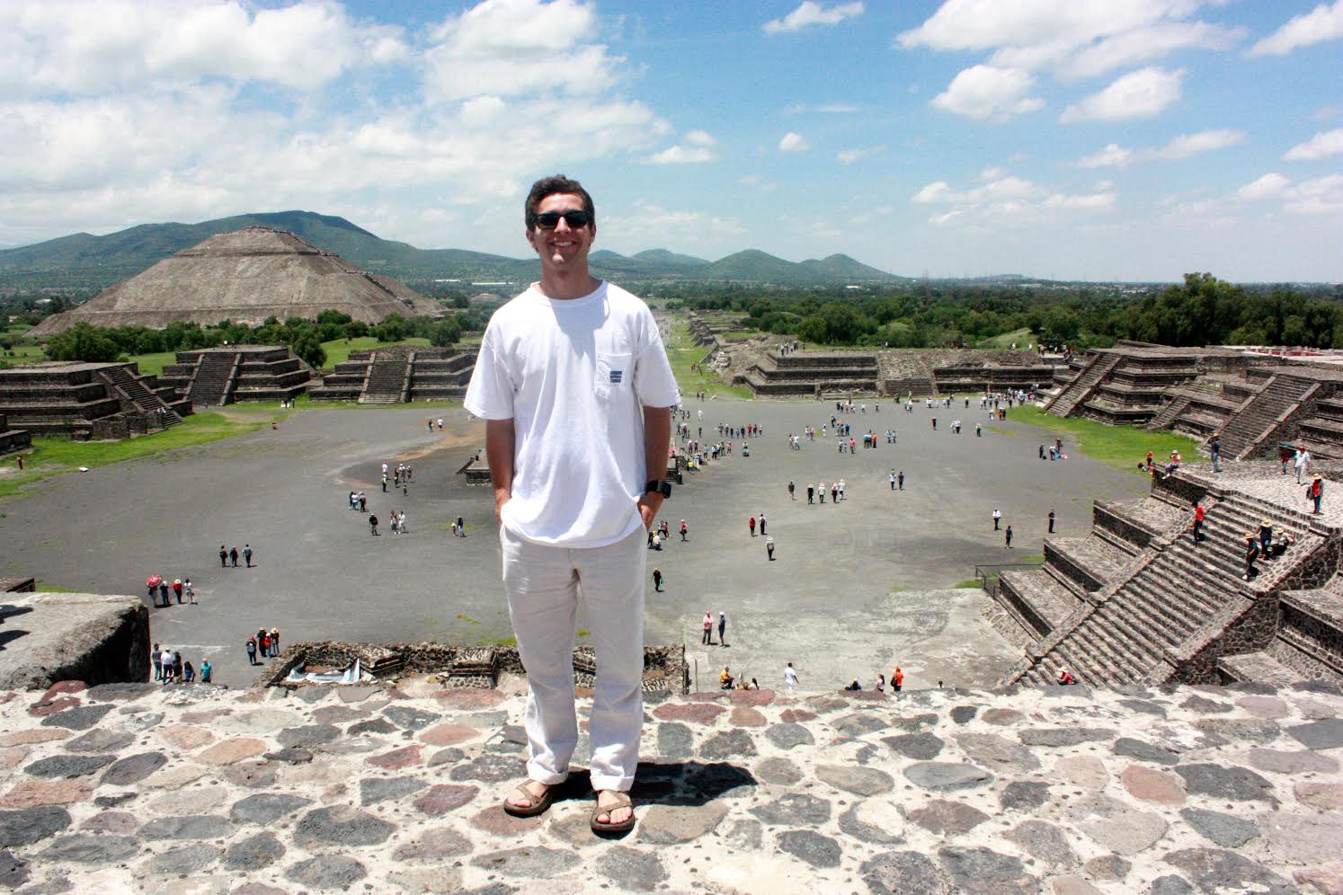 Student poses at top of pyramid.