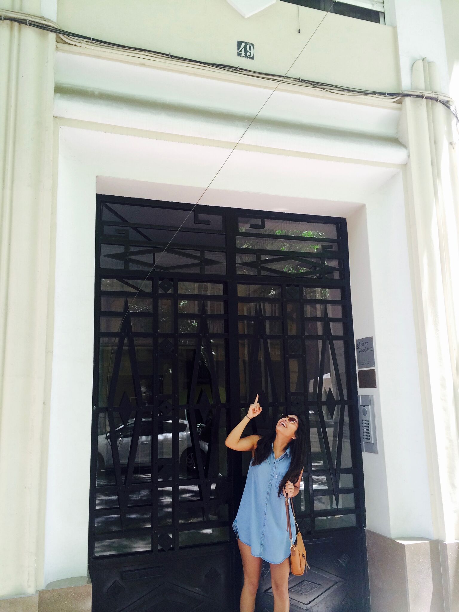 Young woman in front of an imposing doorway.