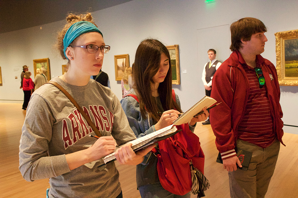 Students sketch in front of a painting. 