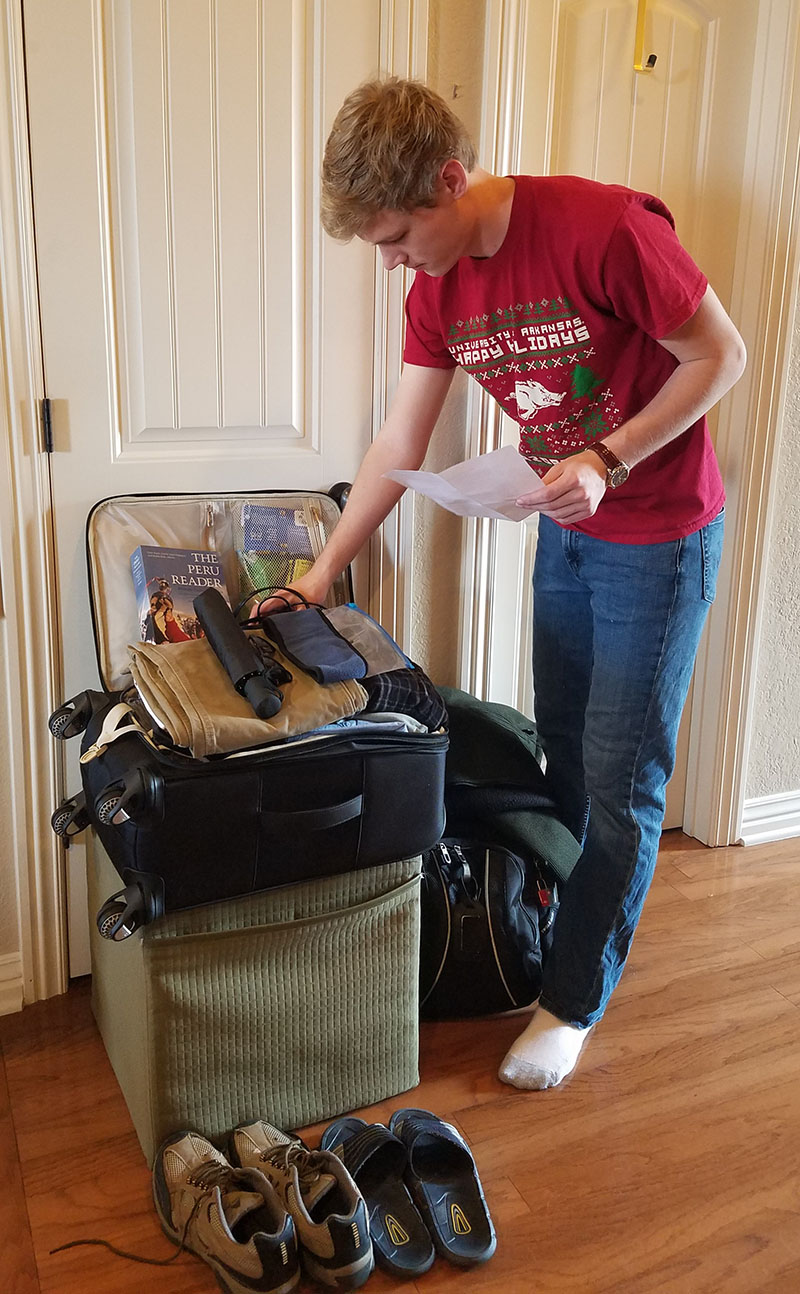 Student packs small suitcase.