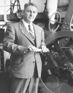 black and white portrait of a man holding a slide rule