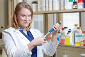 a woman in a lab coat fills a syringe