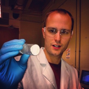 student holding a glass jar with a white substance