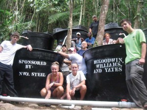 a group of students posing with large black barrels