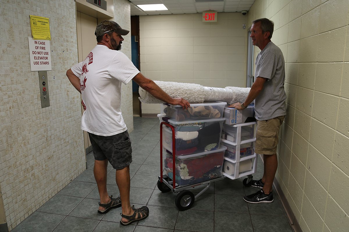 Pomfret dads discuss their progress in the Pomfret B-Wing elevator lobby.