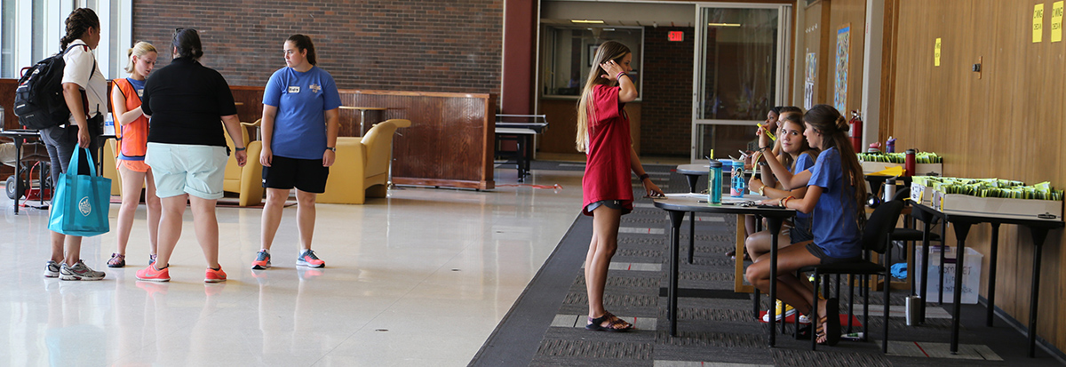 At left , Dr. Stephanie Adams, Remington Gould, Amanda Bobo and Hayley Maxwell meet while RAs work a check-in at right.