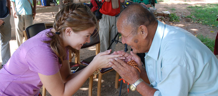 Man and a young woman greeting with hands in prayer positon. 