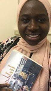 mariyamou smiles as she holds in hand paul stoller's "money has no smell" book