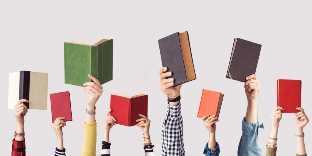 Hands holding books in the air