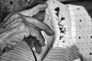 Primer plano de la mano de una abuela, apoyada en la barnbilla