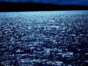 océano azul brillante durante la noche