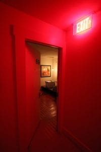 Puerta y pared rojos con letrero neón de "exit"