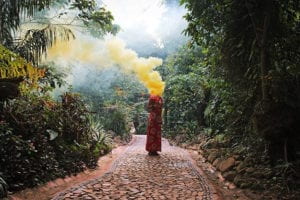 mujer en medio de selva con bengala amarilla