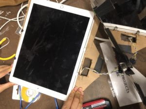 Process of placing an ipad that would be hung with the frame and double sided mirror in front of it.