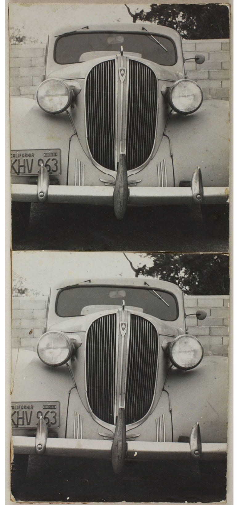 Black and white photo of the front of an old car.