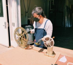 Ana Salas inspects a film in preparation for mold remediation.