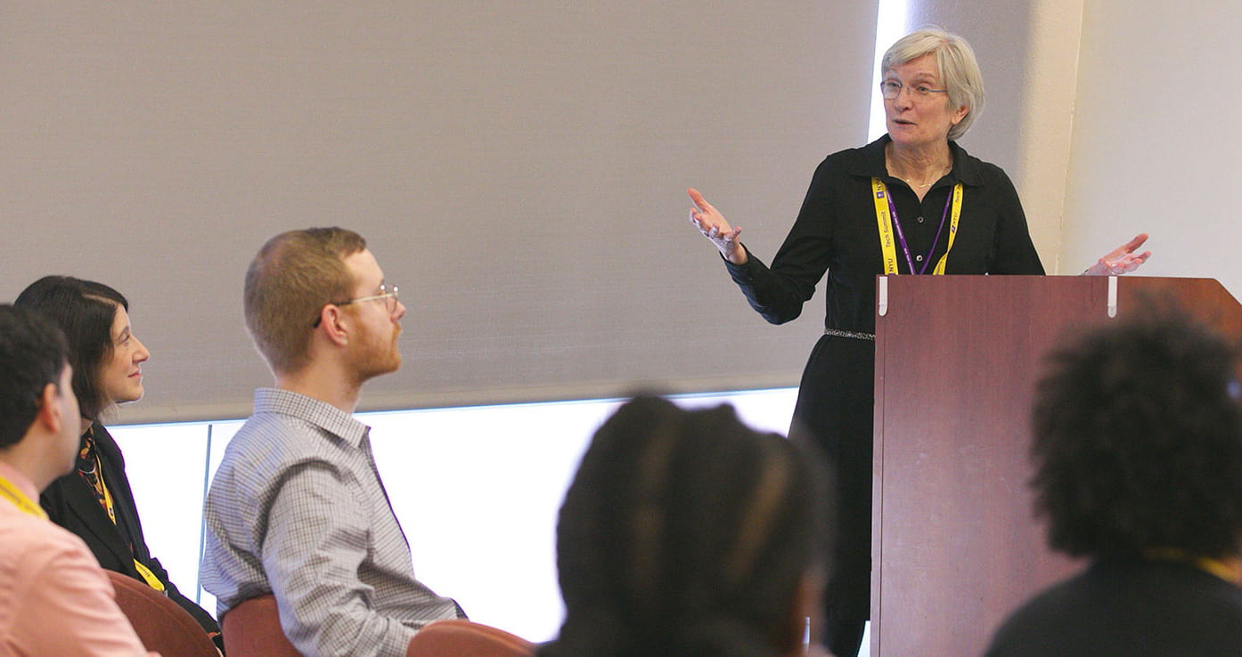 Kitty Bridges standing a podium addressing an audience