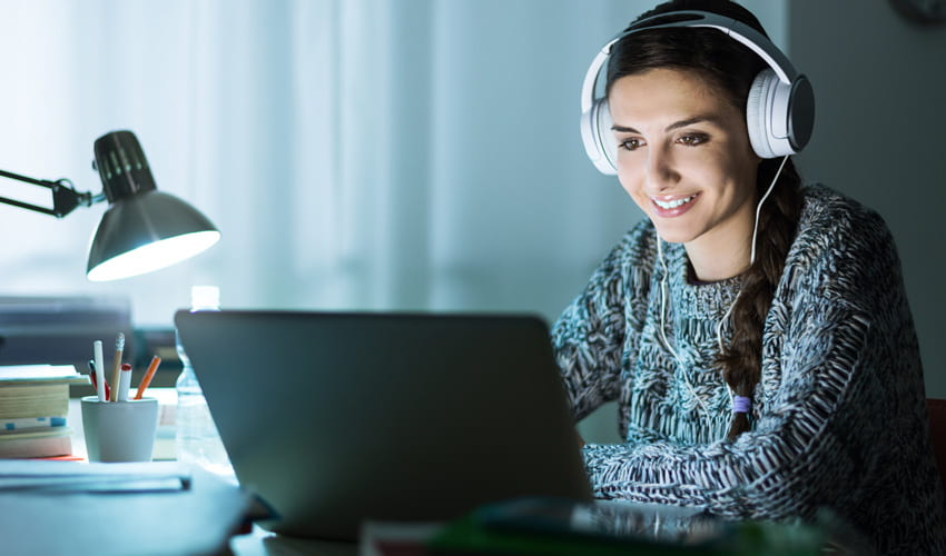 woman wearing headphones working on laptop