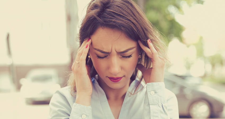 Woman suffering from a headache, holding her head