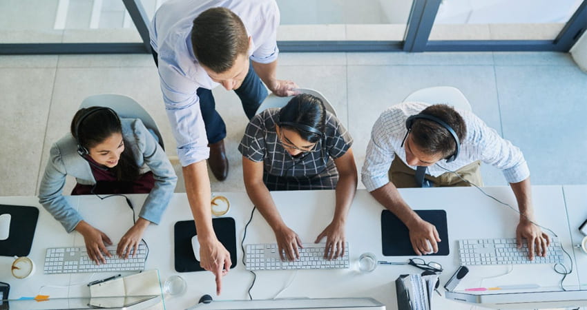 four people working at laptops