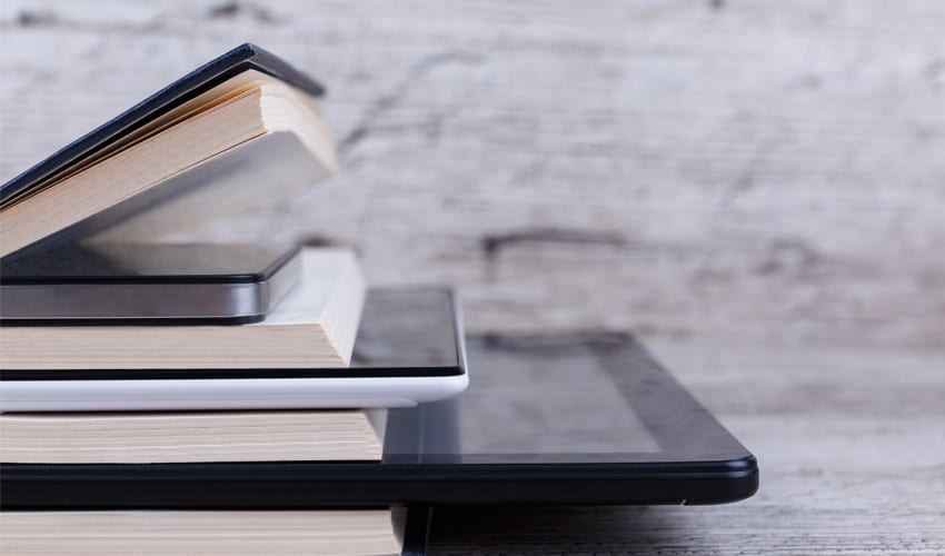 a stack of books, a smart phone, and a digital tablet