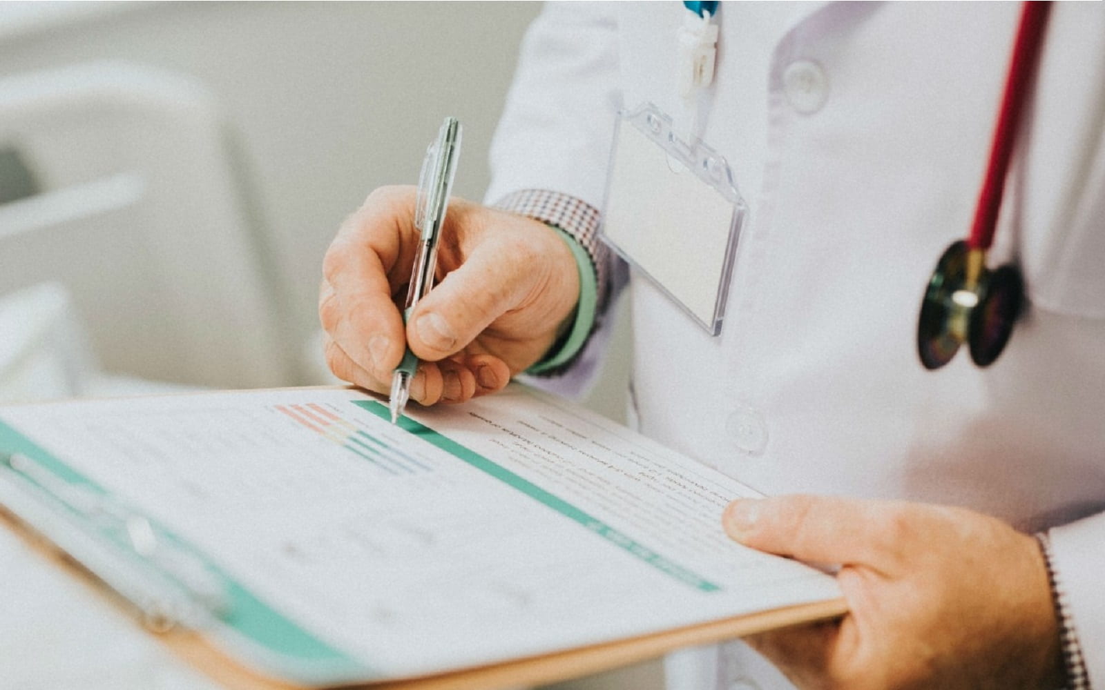 Doctor wearing lab coat and stethescope and holding clipboard