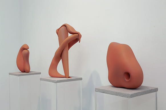 Three amorphous sculptures on pedestals.