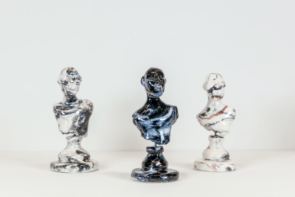 Three ceramic busts one blue in center, two white.