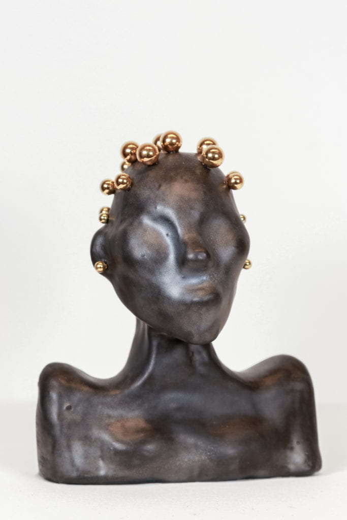 Ceramic bust with dark clay and gold hair.