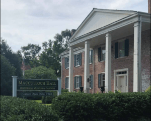 2 story colonial building with shrubs in foreground.