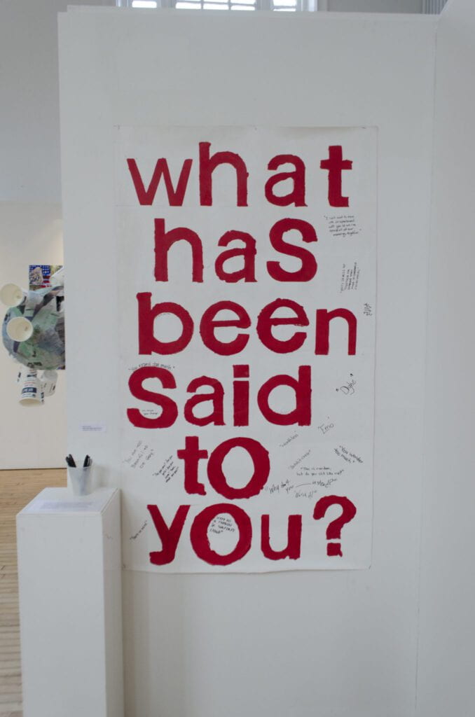 Exhibition sign that reads "What Has Been Said to You?"