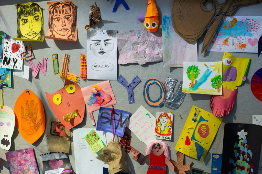 a wall of different handmade art images including portraits and funny faces