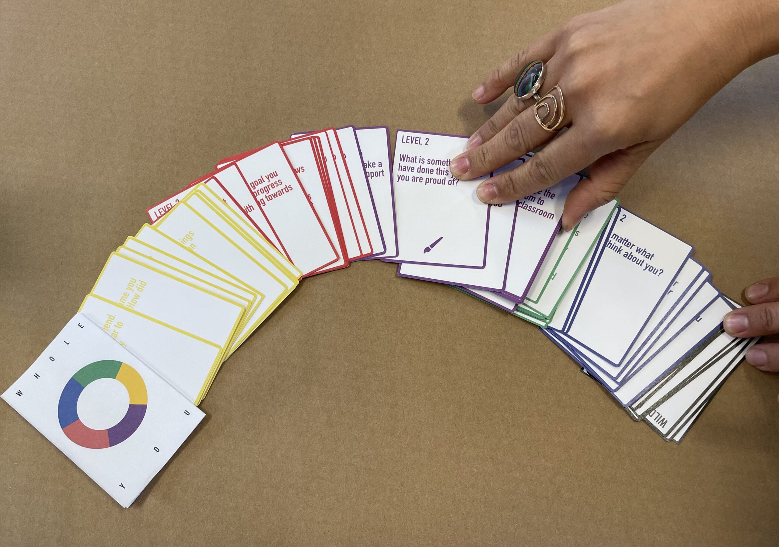 Photograph of a deck of colored cards and hand selecting a card