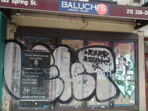 Many graffiti images on the front of an abandoned store