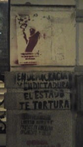 Gray building side with stenciled graffiti and spanish exclamations 