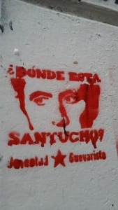 Stenciled graffiti with a male face and words in spanish