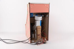 View of the back and internal components of "Bon Appetit" on the game console including thermal printer, arduino, wires attached to breadboard, and cardboard dispenser